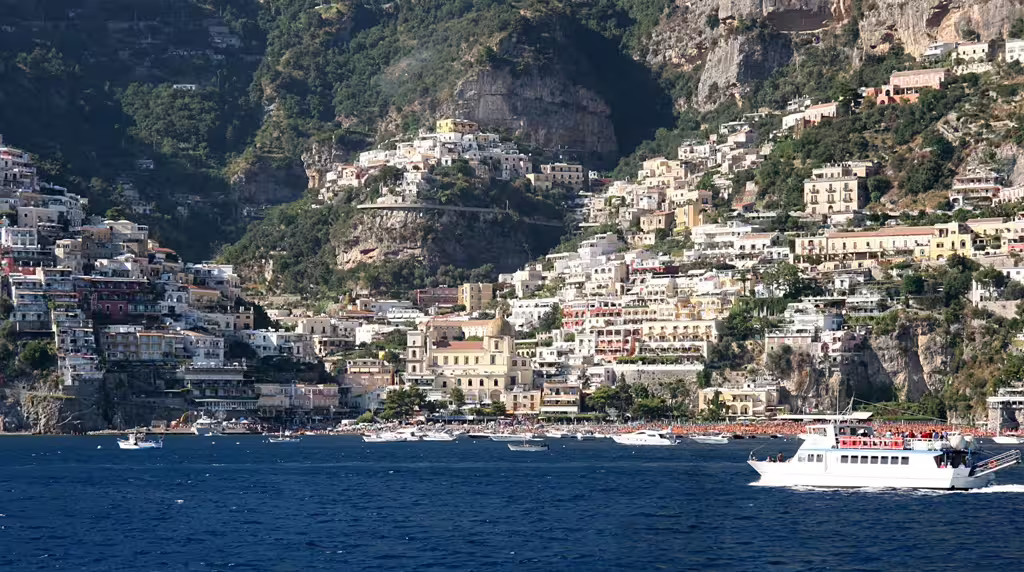 Boat approaching Positano’s colorful cliffside village on the Amalfi Coast, featured on private Positano and Pompei tour