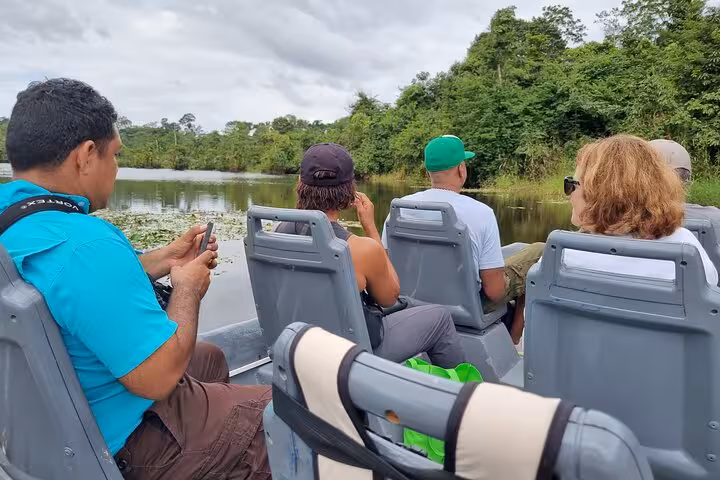 Tourists capturing moments on a Rio Frio boat safari, immersed in tropical landscapes and wildlife.