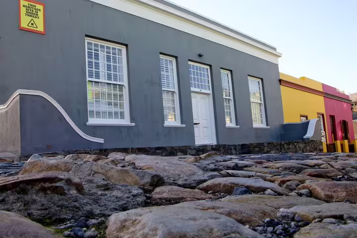 Historic Bo-Kaap building with cobblestone street, featuring Cape Town's iconic colorful architecture.