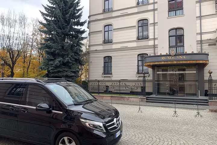 Luxury Mercedes van in front of a classic hotel entrance, showcasing premium Bologna airport to Ravenna cruise transfer.