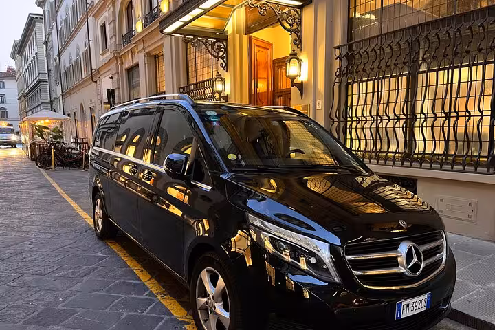 Luxury black Mercedes van parked in Bologna's historic district for airport to Ravenna cruise terminal transfer.