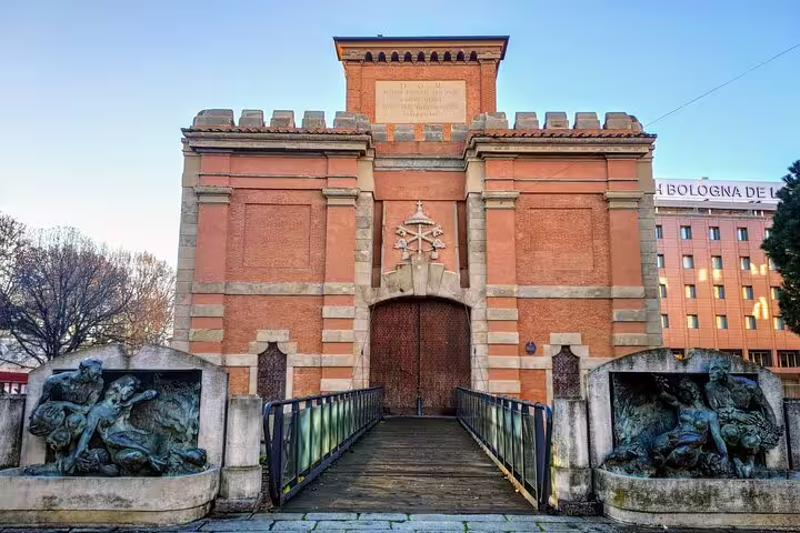 Historic medieval gate with bronze sculptures and wooden bridge in Bologna old town