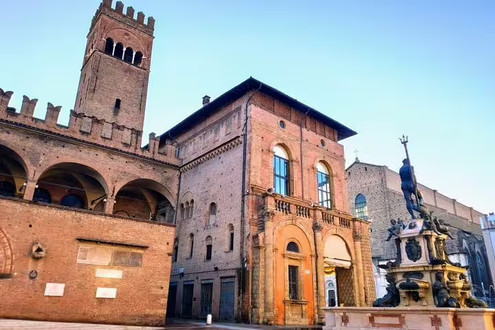 Piazza Maggiore Bologna with Neptune Fountain and medieval Palazzo Re Enzo at golden hour