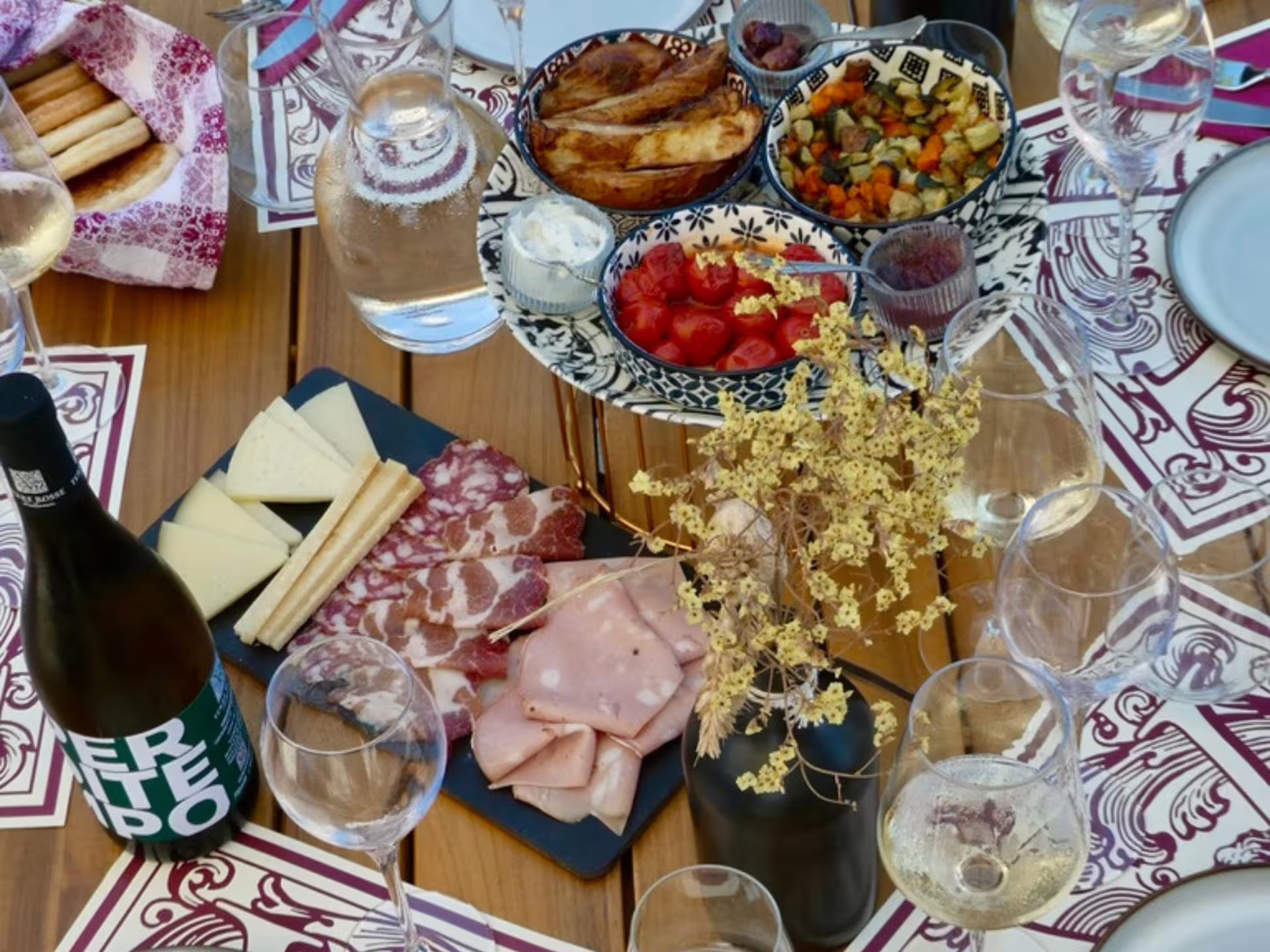 Wine tasting food platter in Bologna with local salumi, cheeses, bread and glasses at boutique winery