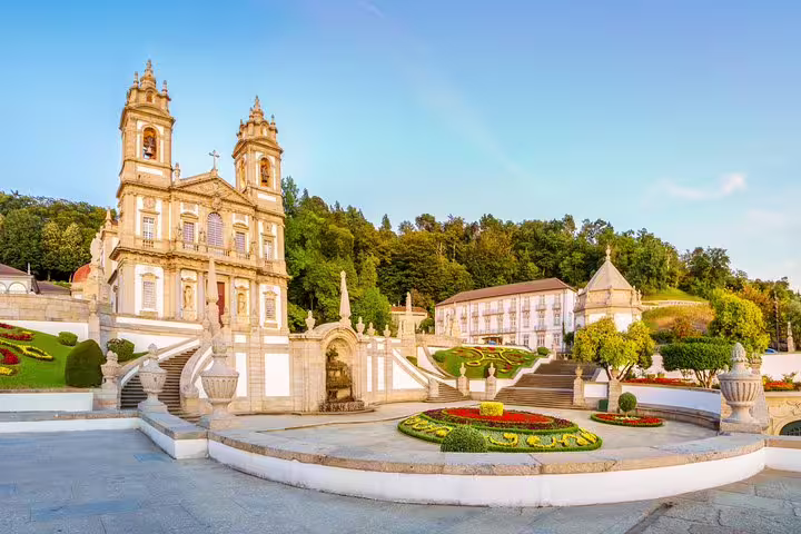 View of Bom Jesus do Monte sanctuary in Braga, showcasing stunning baroque architecture and vibrant gardens on a sunny day.