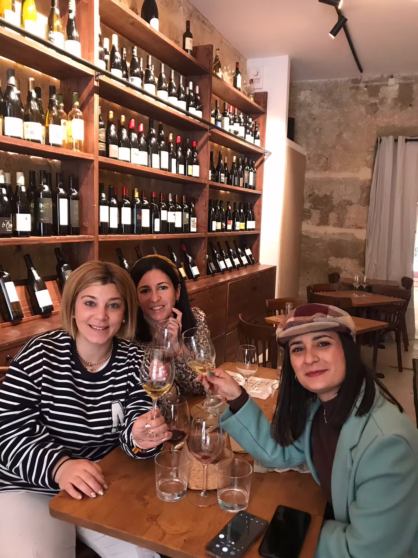 Friends toast at Bordeaux blind natural wine tasting with cheese and charcuterie pairing in intimate wine bar