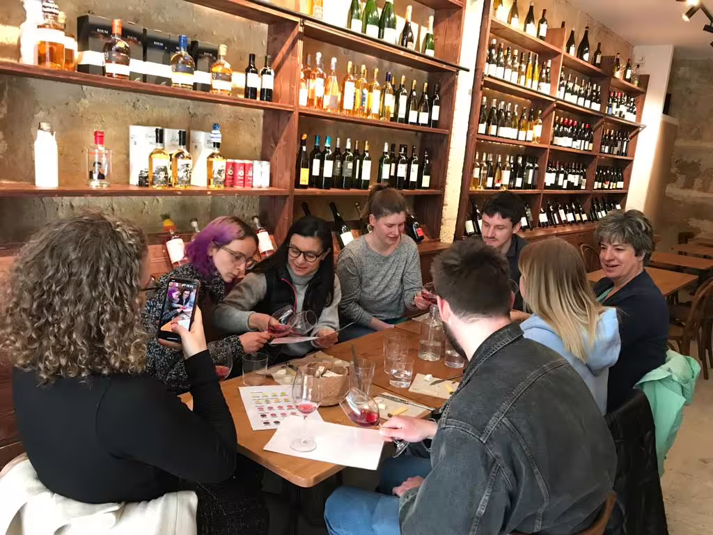 Group blind tasting Bordeaux natural wines with cheese and charcuterie pairing in cozy wine bar cellar