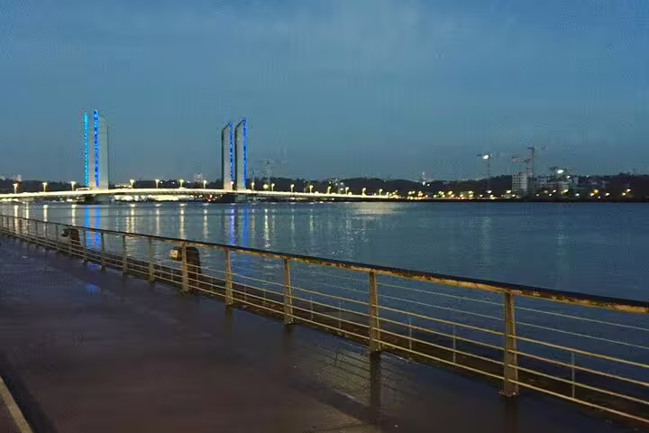 Evening walk along Bordeaux Garonne River with Pont Jacques Chaban-Delmas lights on small group tour