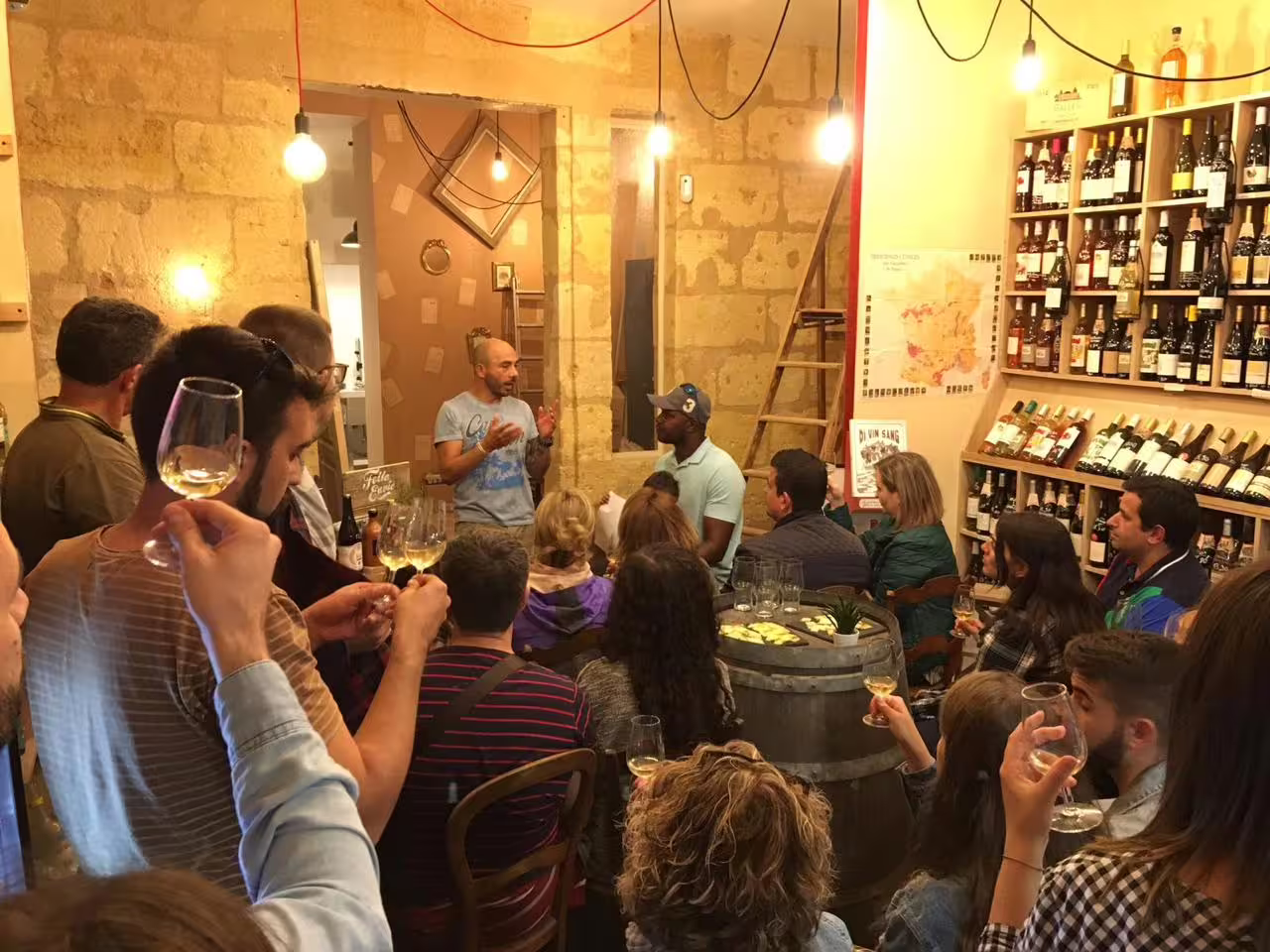 Natural wine tasting in Bordeaux wine bar during private walking tour, guests sipping local white wine