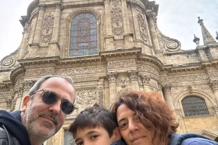 Family selfie in front of ornate Baroque stone facade during Bordeaux Old Town walking tour
