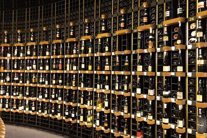 Extensive wine cellar showcasing diverse Bordeaux wine bottles on display during a private walking tour.