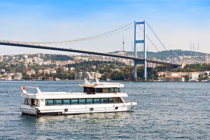 Bosphorus cruise boat under the Bosphorus Bridge in Istanbul on a 6-day guided Istanbul Cappadocia tour