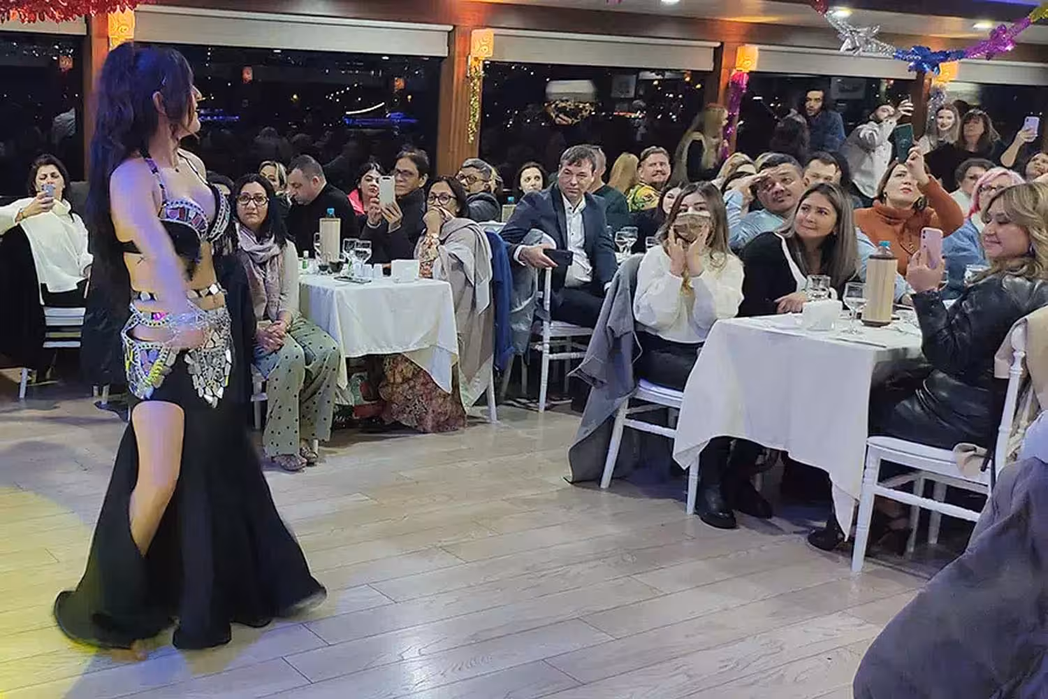 Belly dancer performing for guests on Istanbul Bosphorus dinner cruise with Turkish night entertainment