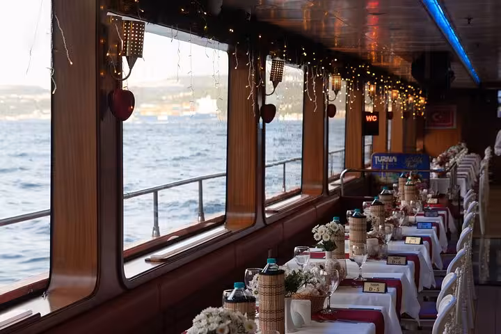 Private table set for Bosphorus dinner cruise with sea-view windows, elegant decor and Istanbul evening sailing