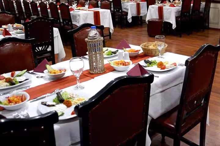 Group enjoying a private table dinner on Bosphorus cruise in Istanbul with mezze, wine glasses and flags