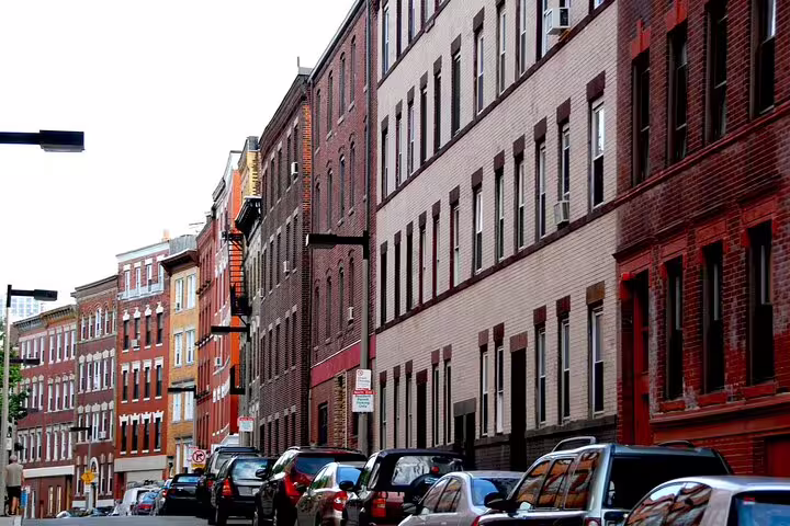 Historic red brick buildings lining a narrow street in Boston's North End neighborhood