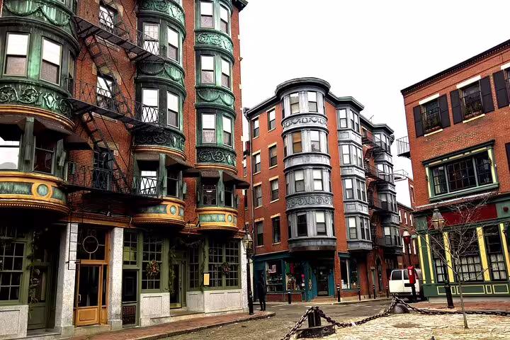 Historic brick buildings with ornate bay windows and fire escapes in Boston's North End neighborhood