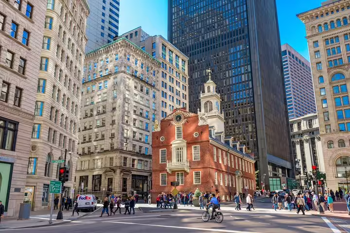 Old State House surrounded by modern skyscrapers on a busy Boston street with pedestrians