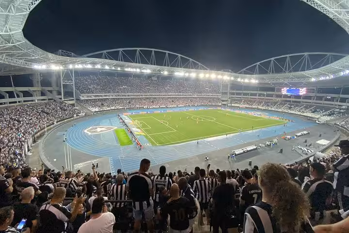 Night view of Nilton Santos Stadium crowd in Rio during Botafogo match, join locals football game tour