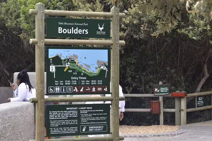 Entrance sign for Boulders Beach, Table Mountain National Park, showcasing entry times and park information.