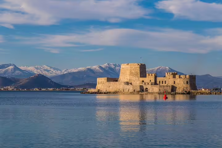 Bourtzi Castle in Nafplio harbor with mountains, scenic stop on Mycenae Corinth Canal Nafplio private trip