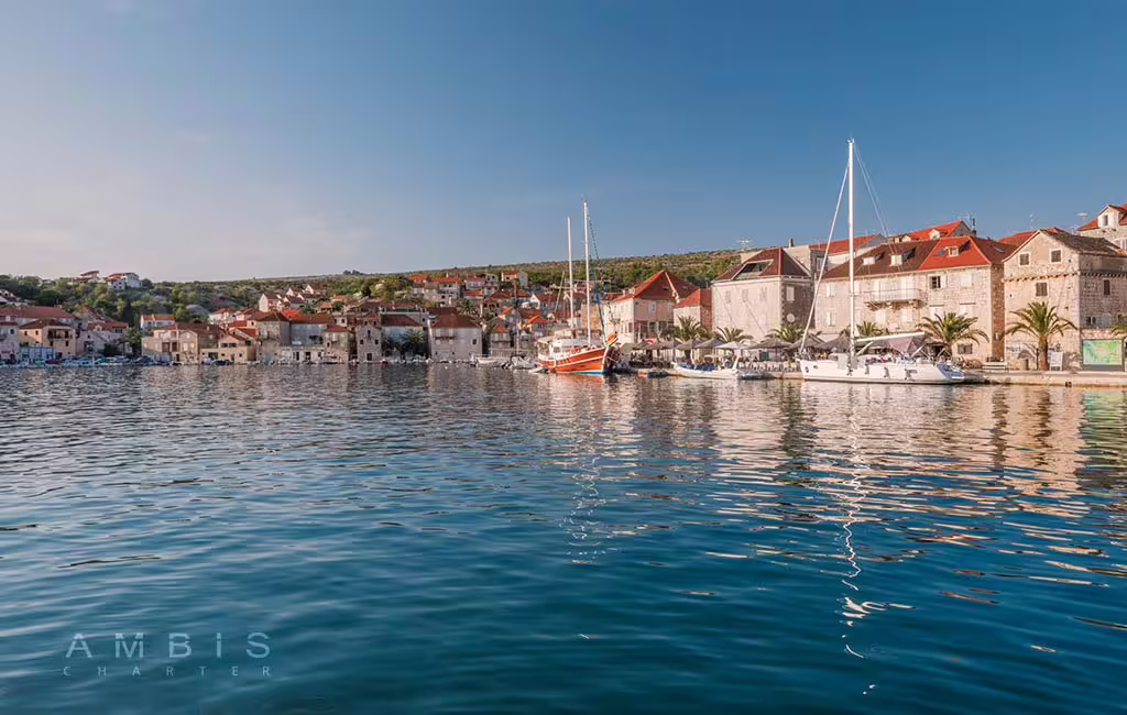 Harbor view with sailboats and stone waterfront in Solta, Dalmatian island stop on Brac and Solta private boat tour
