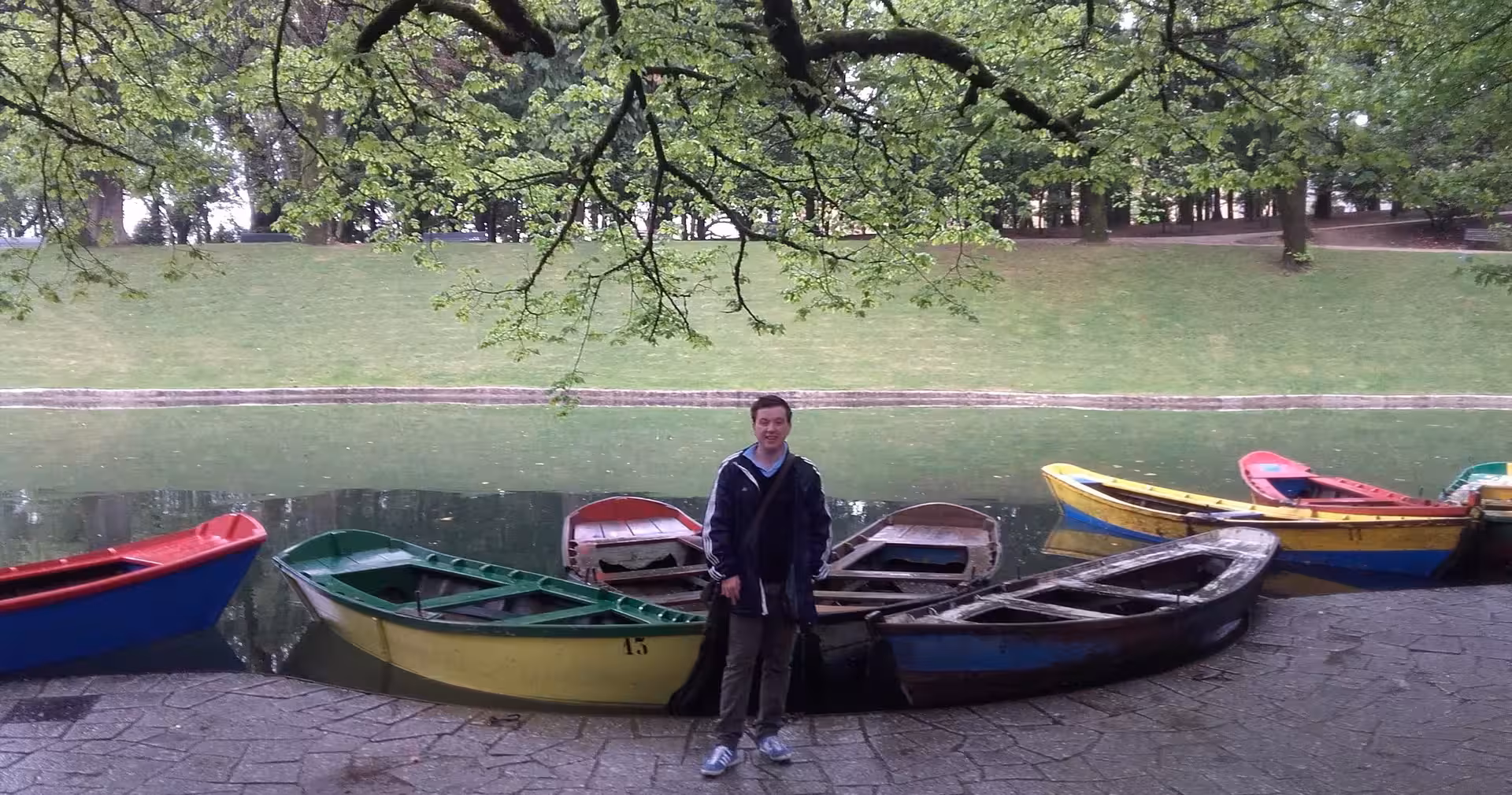 Traveler by colorful rowboats on a calm lake in Braga, a relaxing stop on a half-day small-group city tour