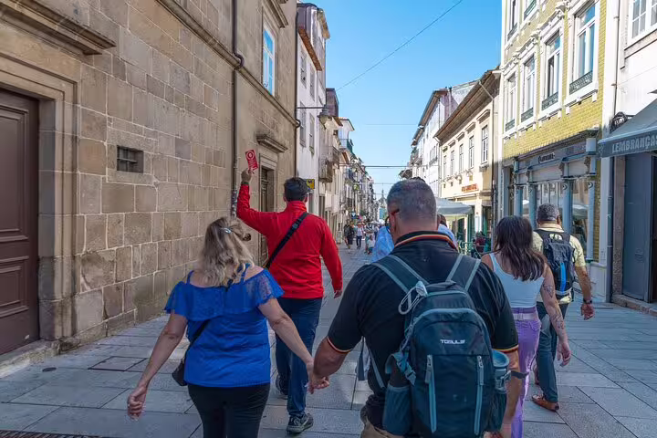 Tour group strolls through picturesque streets of Braga, led by a guide on a small group tour with hotel pick-up.
