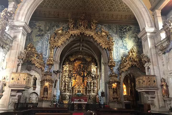 Ornate interior of a historic church in Braga, showcasing intricate gold details and vibrant blue azulejos.