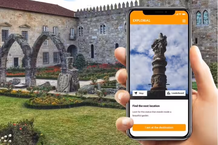 Phone app guiding a Braga scavenger hunt in a historic garden courtyard near Braga Cathedral on a self-guided tour