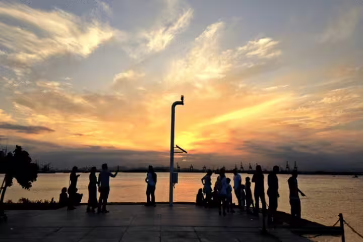 People enjoying a vibrant sunset over Guanabara Bay, highlighting the beauty of the Brazil Imperial tour experience.