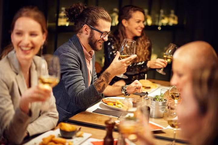 Group enjoying Brazilian BBQ with wine at a lively dinner experience in Rio, showcasing local cuisine and camaraderie.