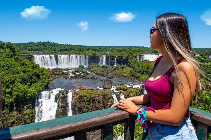 Woman enjoying a panoramic view of the stunning Brazilian waterfalls surrounded by lush greenery.