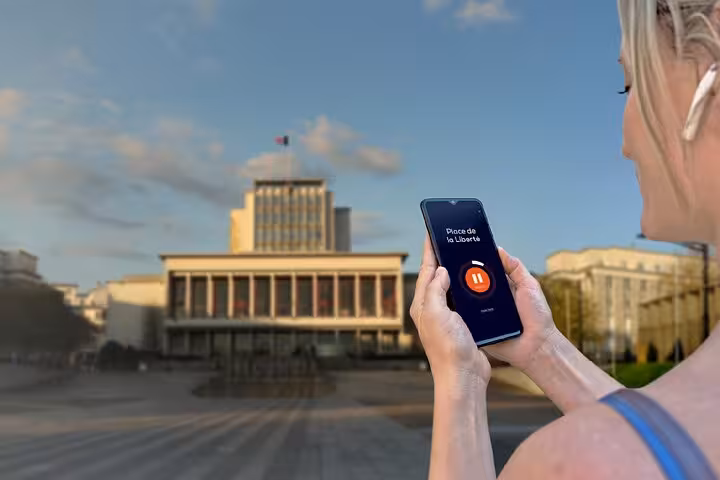 Woman holding smartphone with GPS audio guide app at Place de la Liberté in Brest, France
