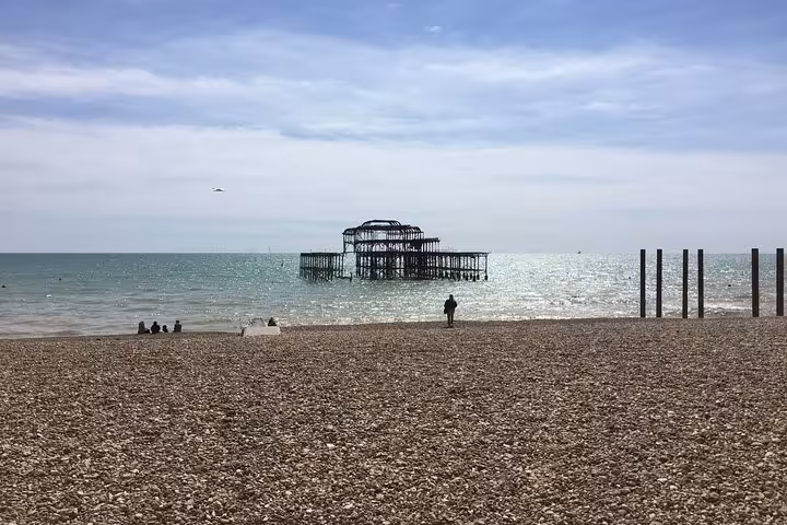 Brighton West Pier ruins on pebble beach with calm sea and overcast sky