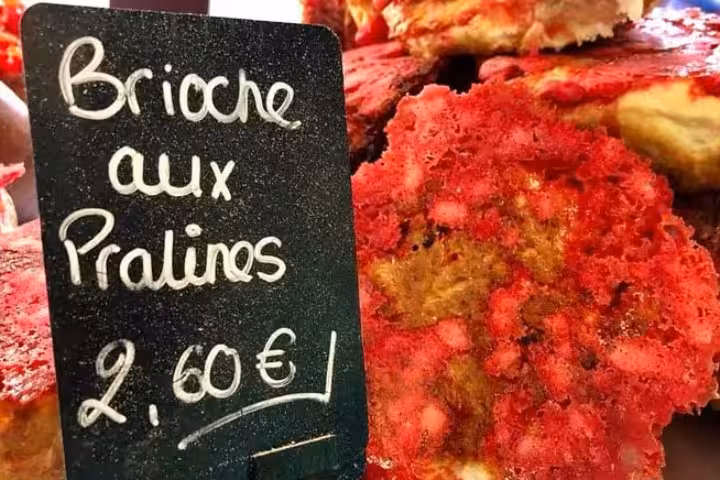 Close-up of Brioche aux Pralines with price tag at Lyon Old Town bakery, highlighting traditional French pastry.