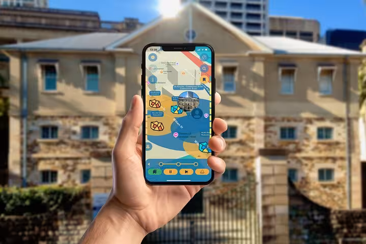 Hand holding smartphone displaying interactive map app for self-guided convict walking tour in Brisbane