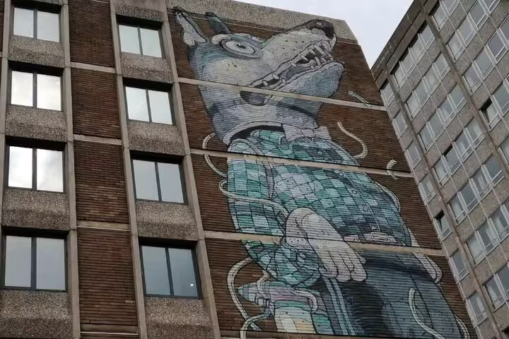 Large wolf street art mural painted on the side of a multi-storey building in Bristol city centre