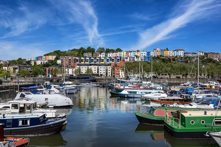 Colorful houses overlooking Bristol's harbourside marina with boats moored on calm reflective water