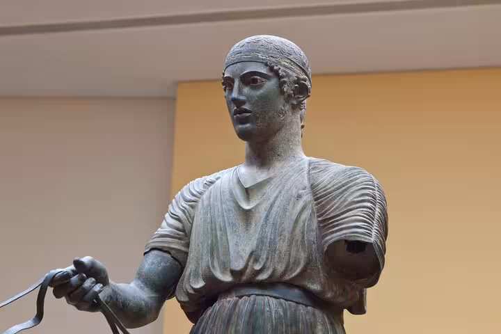 Ancient bronze charioteer statue at Delphi Archaeological Museum, key visit on 2-day Delphi and Meteora private tour