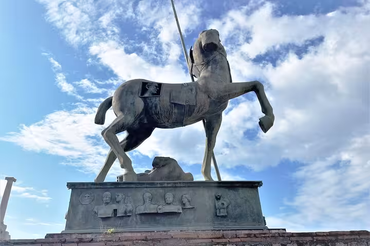 Bronze horse statue under a blue sky in Pompeii, a highlight of the semi-private tour from Positano to Mt. Vesuvius.
