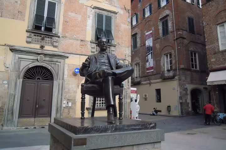 Bronze statue in Lucca’s old town square, highlighting cultural stops on a private Pisa and Lucca wine tour