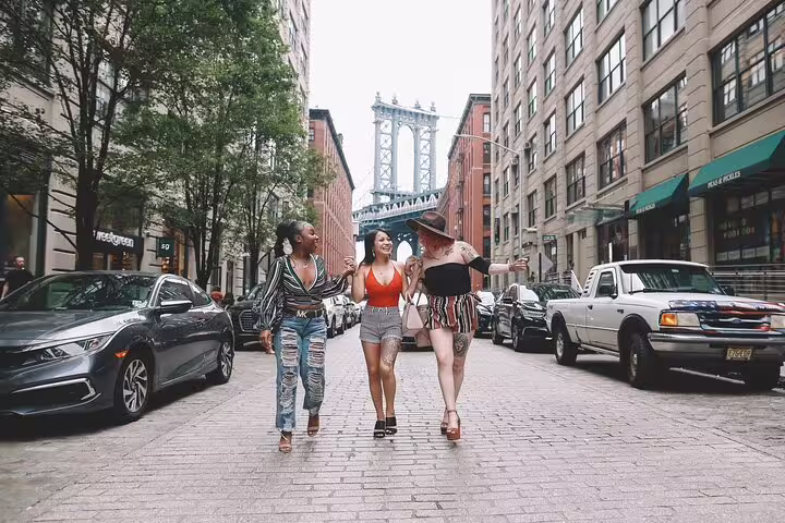 Friends walking on Washington Street DUMBO with Manhattan Bridge view during a Brooklyn personal photo tour NYC