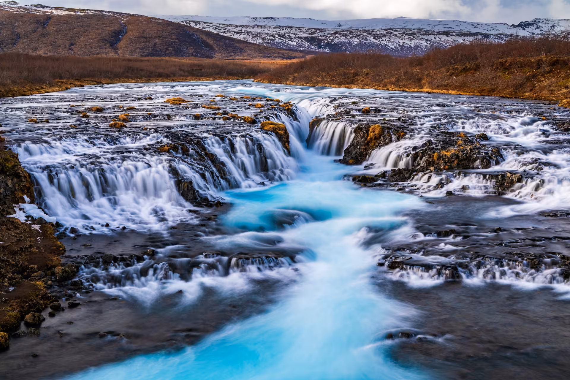 Bruarfoss waterfall with vivid turquoise water cascading over dark rocks in Iceland's golden circle