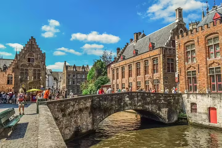 Stone bridge over Bruges canal with medieval buildings, ideal start point for a self-guided e-scavenger hunt