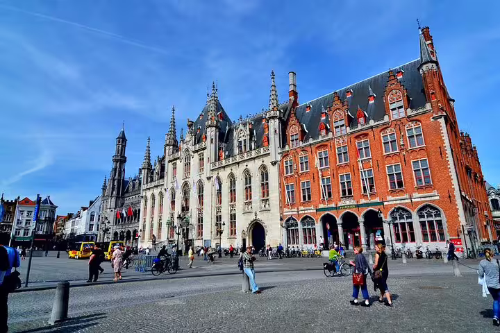 Historic Grote Markt square in Bruges with Gothic Provincial Court building and red brick facade on sunny day
