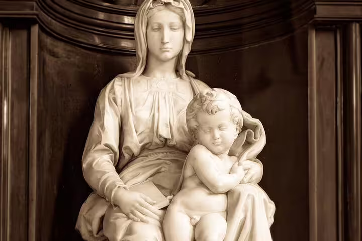 Michelangelo's Madonna and Child marble sculpture, a white stone statue of seated woman holding infant