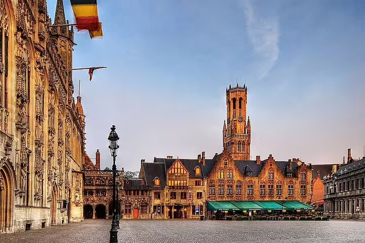 Bruges Markt square with the medieval Belfry tower and Gothic city hall at golden hour