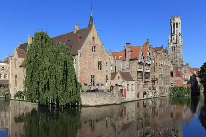 Scenic view of medieval buildings and canal in Bruges, showcasing the historic architecture and charm of a private day trip from Brussels.
