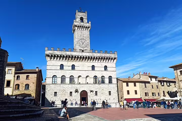 Travelers gather in Montepulciano’s historic Piazza Grande beside the clocktower palace on a Brunello and Nobile wine tour
